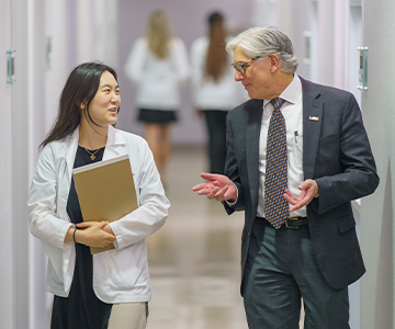 Medical professionals chat as they walk through a hallway. Links to Gifts of Real Estate Medical professionals chat as they walk through a hallway. Links to Gifts of Real Estate